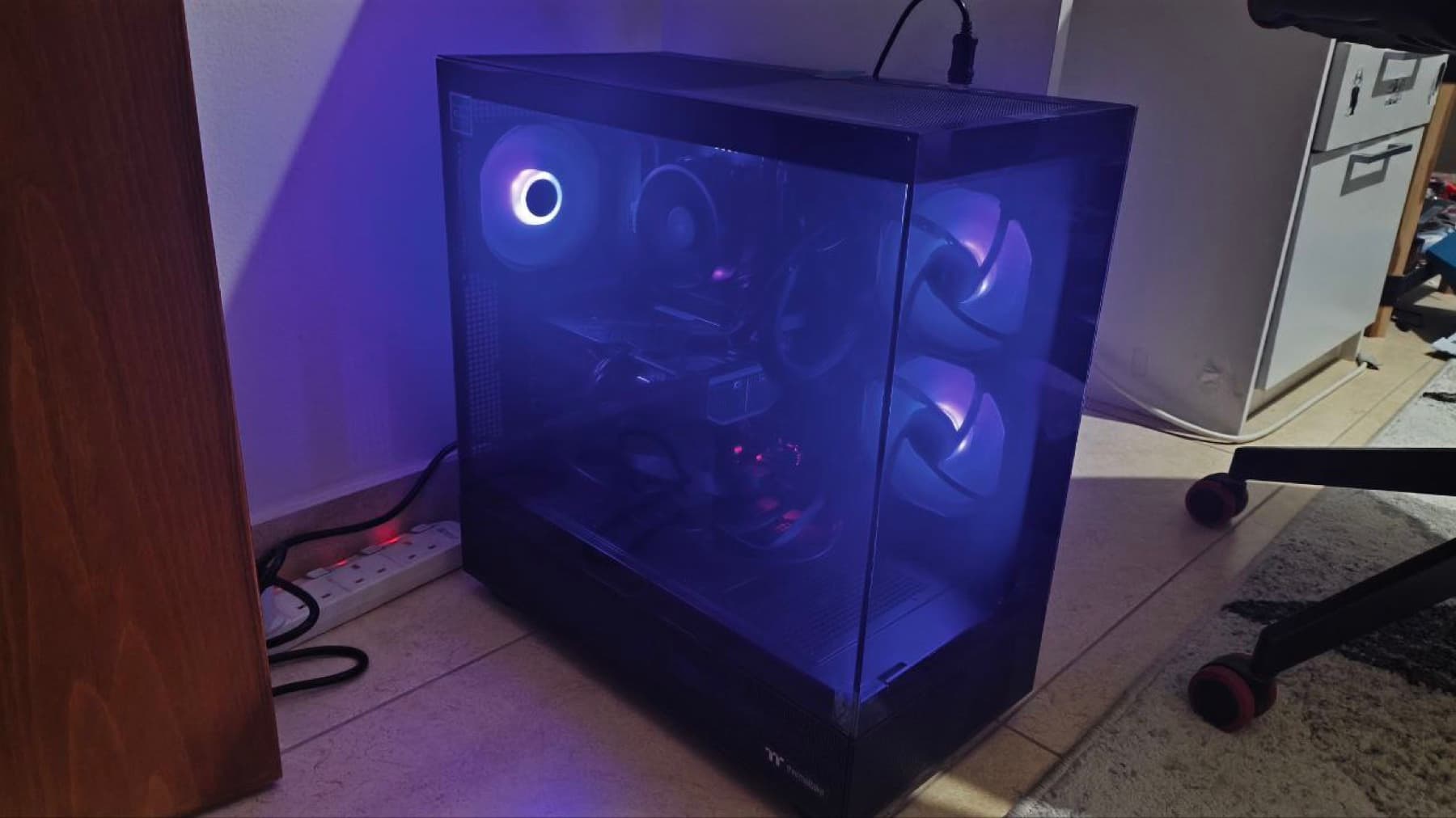 A completed machine in its case with the side panel lit, standing in the room it was delivered to.